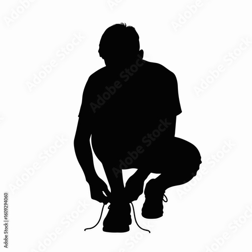 Student tying shoelaces, adjusting his footwear before a run. Student tying shoelaces on a white background showcases a moment of preparation and focus, hinting at fitness and readiness.