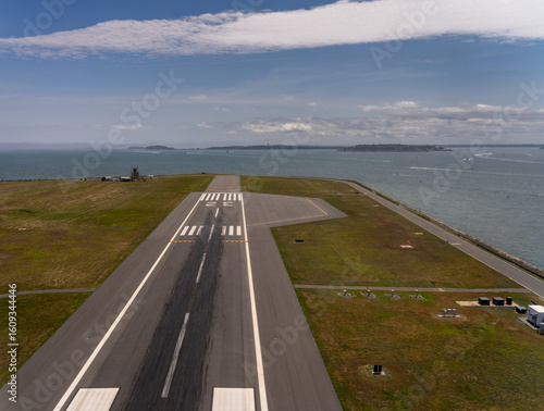 Aerial view of runway near water and islands.