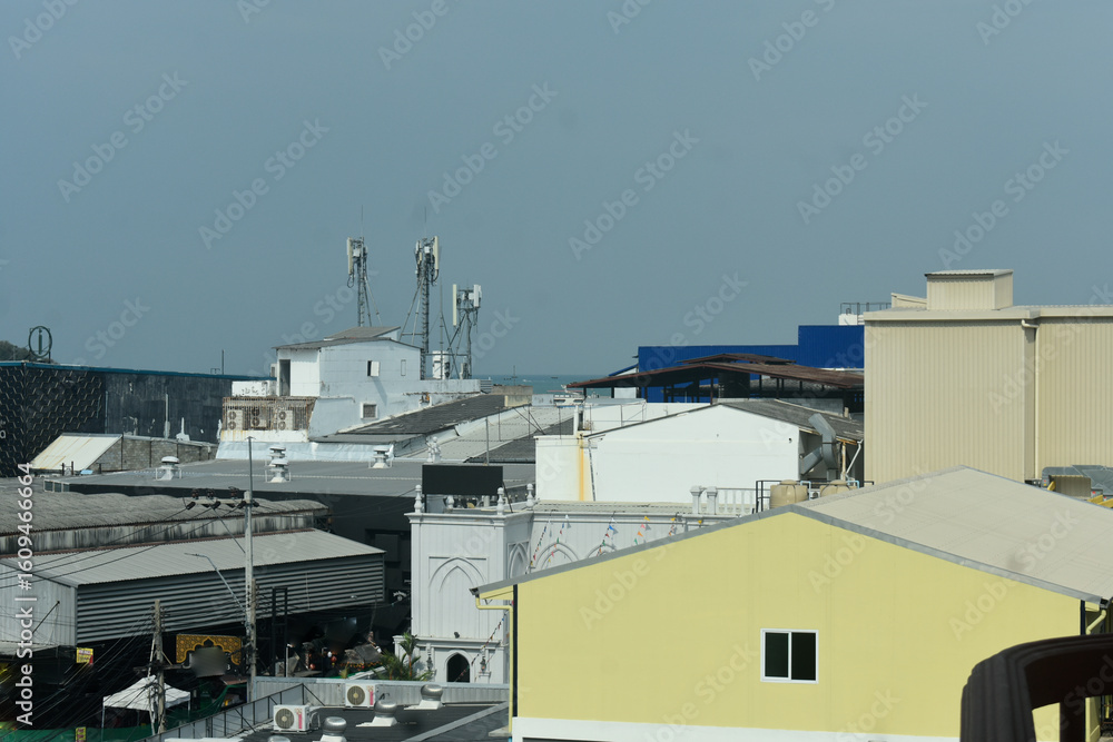 Rooftops of a coastal town with cell towers Rooftops of a coastal town with cell towers