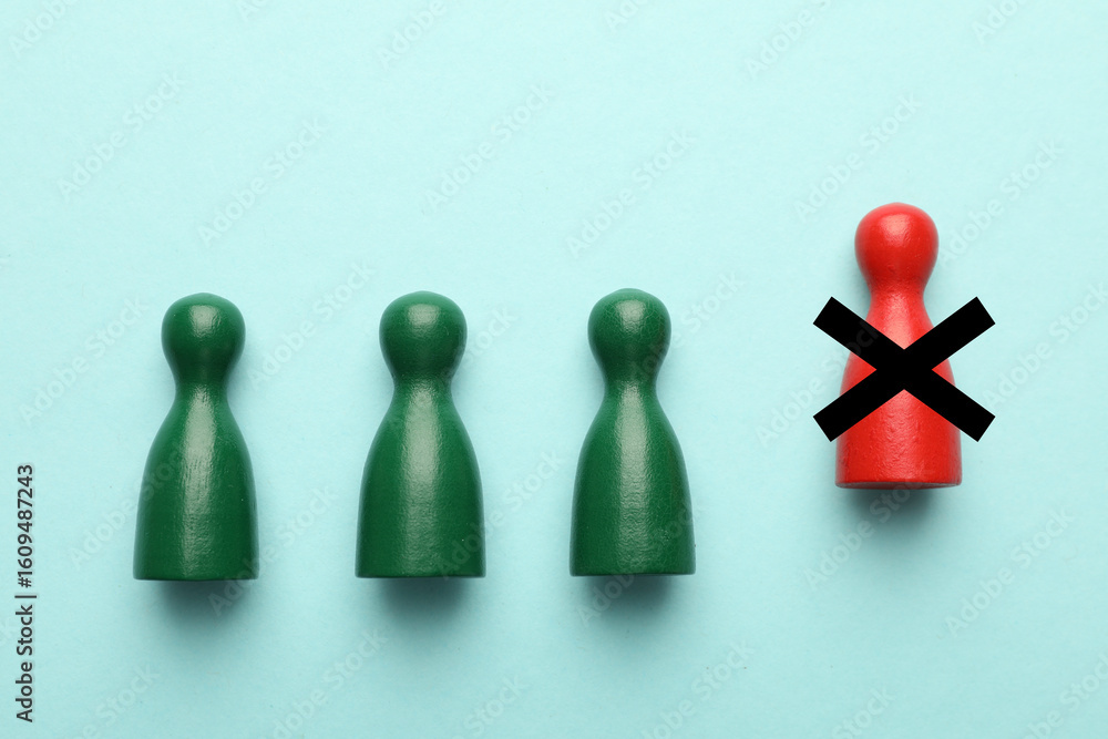 Dismissal. One red human figure with black cross among green ones on light blue background, top view Dismissal. One red human figure with black cross among green ones on light blue background, top view