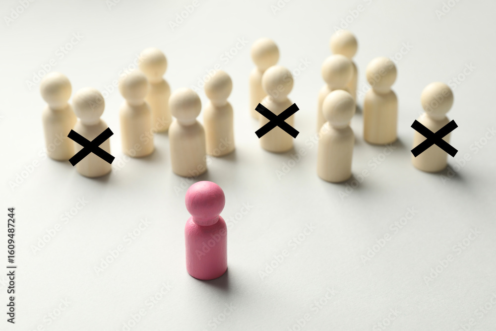 Dismissal. Three human figures with black crosses among others on white table. Pink figure - boss or HR manager Dismissal. Three human figures with black crosses among others on white table. Pink figure - boss or HR manager
