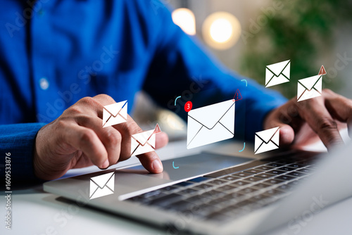 A Businessman working on a laptop open an email with triangle caution warning sign for notification error and maintenance concept, network security, computer virus detected, personal data protection.