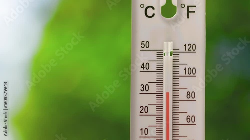 A vertical outdoor thermometer with dual Celsius and Fahrenheit scales showing rapid temperature rise from normal to overheat, indicating heatwave or extreme weather conditions
