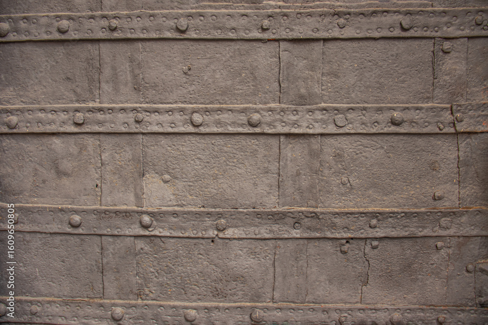 Naklejka premium Detailed view of an old riveted metal surface with weathered texture