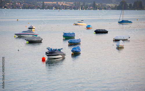 covered boats and yachts staying on buoys near shore