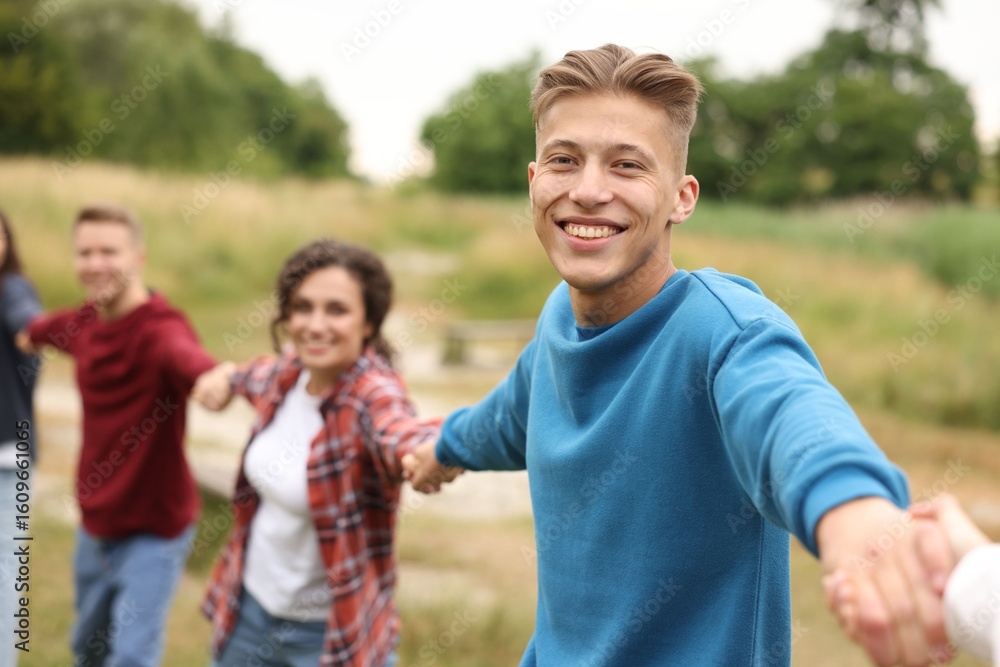 Team building. Group of happy people holding hands outdoors, selective focus Team building. Group of happy people holding hands outdoors, selective focus