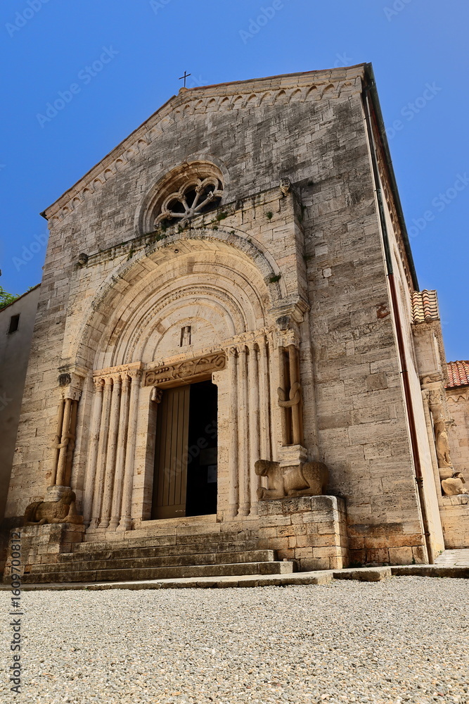 Fototapeta premium Collegiata dei Santi Quirico e Giulitta Church, Romanesque main portal showing two facing crocodiles on the architrave. San Quirico d'Orcia-Italy-121
