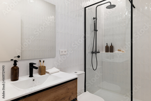 Wallpaper Mural Modern bathroom with a glass shower, white tiles, wooden vanity, and black fixtures. Minimalist design with toiletries on the counter. Torontodigital.ca