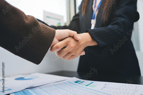 Business people shaking hands in office. Two business partners shaking hands after signing a contract in office.