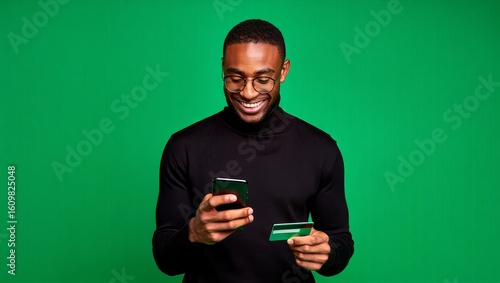 Man online shopping with credit card and mobile phone on green screen background