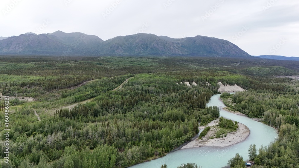 Fototapeta premium Alaskan River with mountain and trees aerial shot