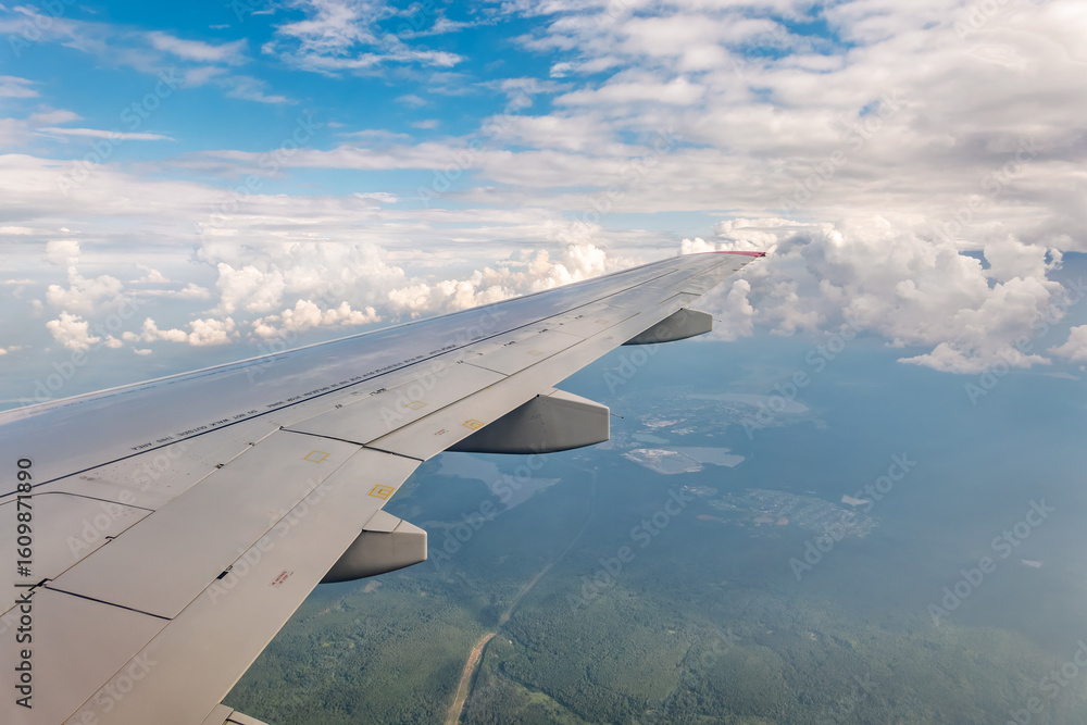 Obraz premium View from the airplane window at a beautiful cloudy sky and the airplane wing