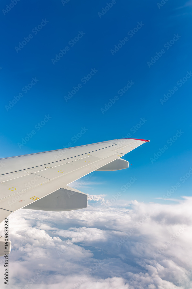 Obraz premium View from the airplane window at a beautiful cloudy sky and the airplane wing