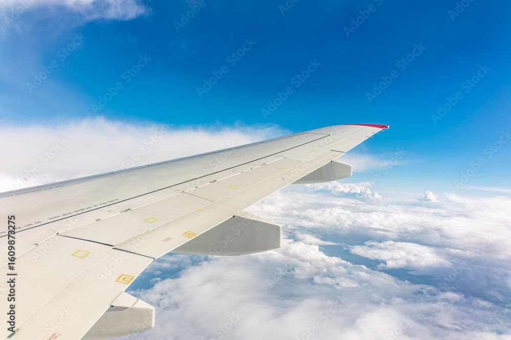 Fototapeta premium View from the airplane window at a beautiful cloudy sky and the airplane wing