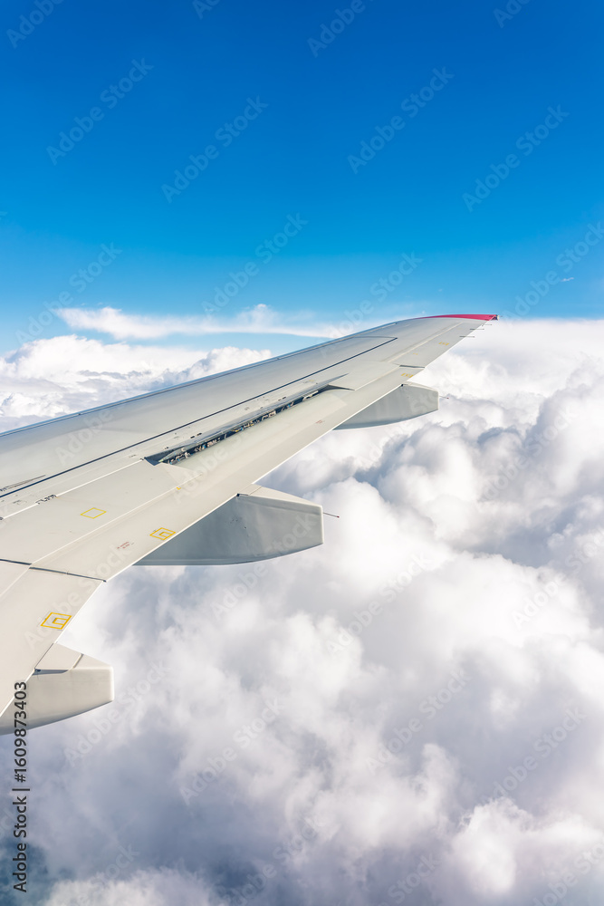 Obraz premium View from the airplane window at a beautiful cloudy sky and the airplane wing