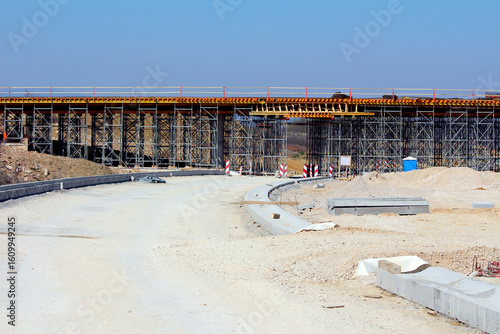 Foto A major bridge is being constructed using extensive scaffolding, with earthworks
