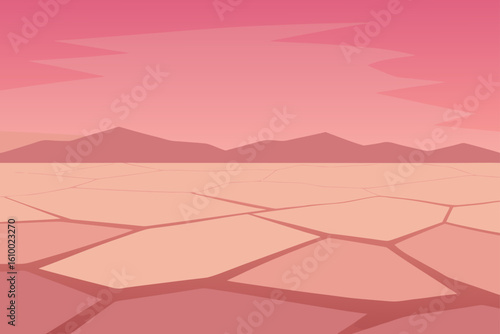 Cracked earth landscape with distant mountains under a pink sky