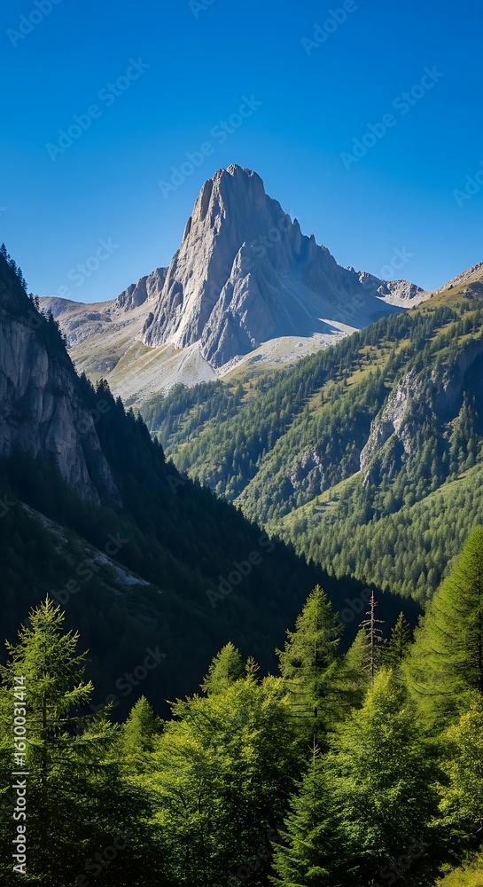 Fototapeta premium Majestic mountain peak over a lush green forest valley
