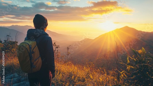 A traveler gazes out at a stunning mountaintop sunrise feeling a deep sense of felicity and peace in the solitude of nature