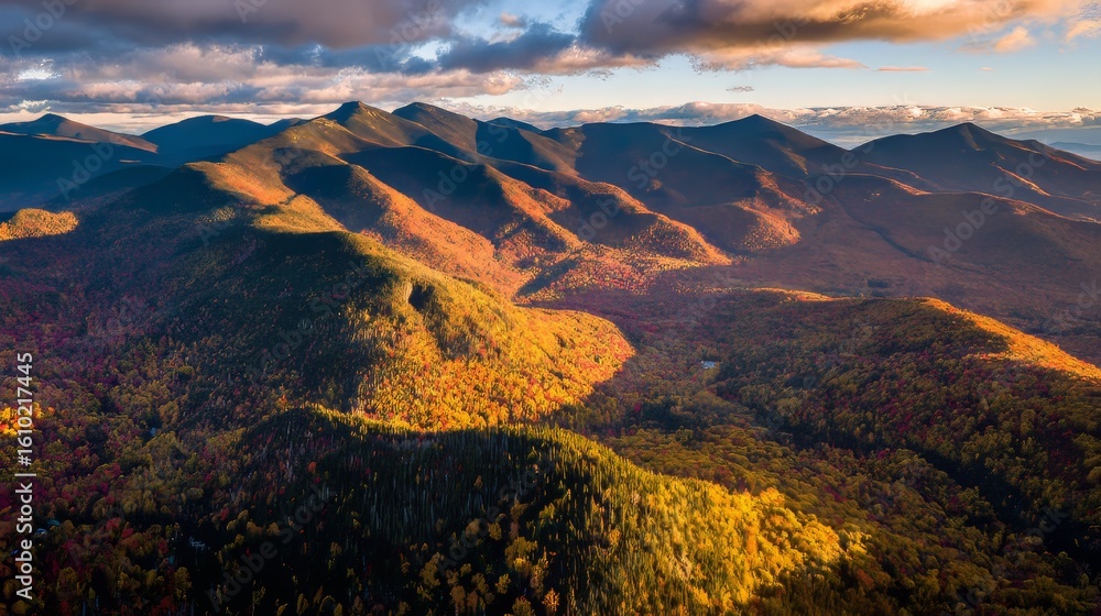 Fototapeta premium Stunning aerial view of colorful fall foliage in New Hampshire with mountains and forests bathed in golden sunlight, showcasing vibrant reds, oranges, yellows, greens, and purples during autumn season