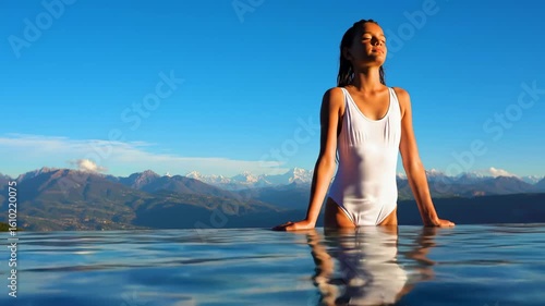 Girl in a white swimsuit by a mountain pool