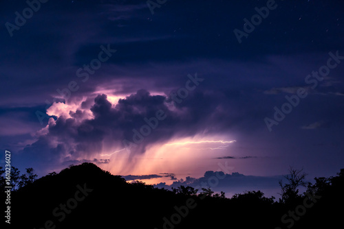 稲光に照らされる雷雲と山のシルエット