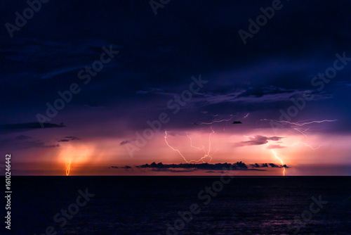 水平線に激しく落雷する海と稲光の夜景