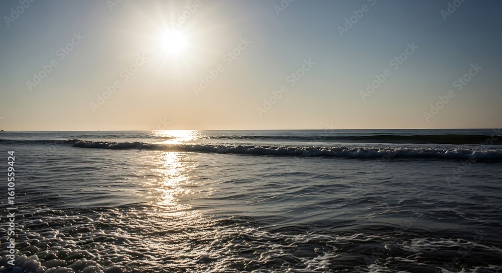 Obraz premium Serene Ocean Waves Reflecting Sunlight During a Peaceful Coastal Sunset