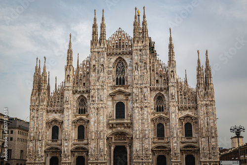 The Milan Cathedral (Duomo di Milano) captured in daylight from the front, showcasing its stunning Gothic architecture with intricate spires and statues under a cloudy sky using landscape photography 