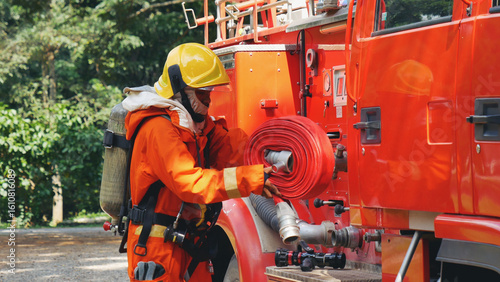 Wallpaper Mural Fireman prepare equipment fighting extinguisher at fire engine truck. Firefighter fighting with smoke flame using fire hose, tube, chemical water foam spray at truck. Fireman wear hard hat protection Torontodigital.ca