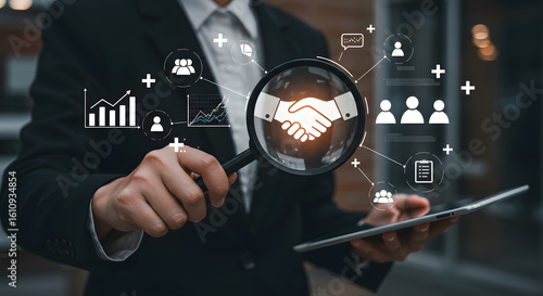 Modern business professional analyzes successful partnership with magnifying glass and tablet