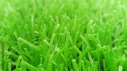 This slow-motion footage captures the realistic texture, lush green color, and soft movement of synthetic turf under natural light
