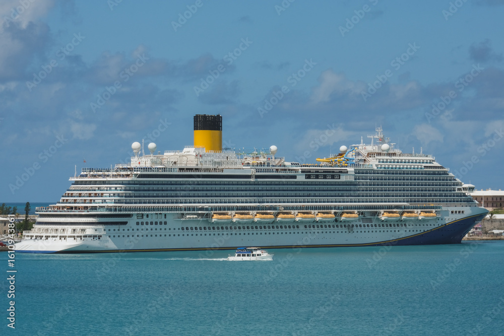 Obraz premium Modern mega family cruiseship cruise ship liner Firenze docked at Royal Navy Dockyard pier near Hamilton, Bermuda on sunny day during Caribbean cruising