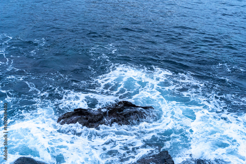 Fototapeta premium The cold Atlantic Ocean is surrounded by cinematic layered rocks that look like a dragon