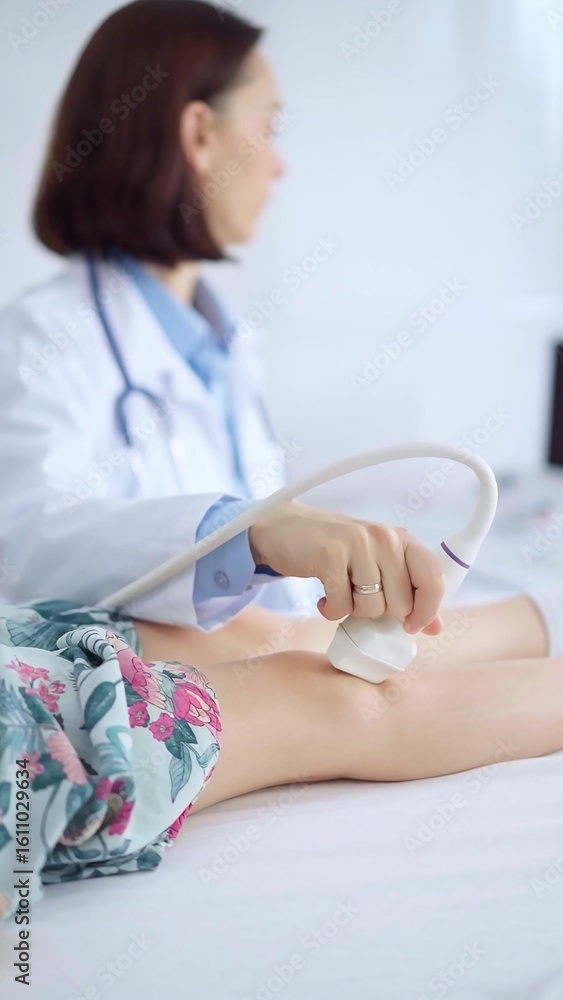 Doctor and kid patient. Orthopedist performing ultrasound examination on a child's knee in a clinic. Medicine and health care Doctor and kid patient. Orthopedist performing ultrasound examination on a child's knee in a clinic. Medicine and health care
