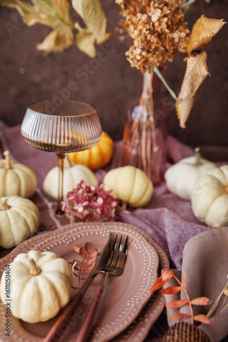 Fototapeta A warm autumn tablescape with white pumpkins, stylish dinnerware, dried florals,