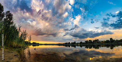 very beautiful sunset with water. summer evening landscape with reflection of clouds in water. setting sun on horizon. summer landscape with lake. reflection of trees in water. sunrise on river