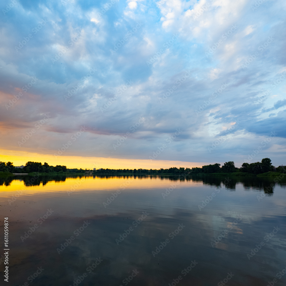 Obraz premium very beautiful sunset with water. summer evening landscape with reflection of clouds in water. setting sun on horizon. summer landscape with lake. reflection of trees in water. sunrise on river