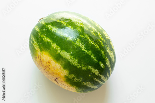 Obraz na plátně Fresh whole watermelon with yellow spot on peel Ukrainian on white background, s