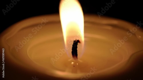 Warm Candle Flame Flickering Softly in Dark Background