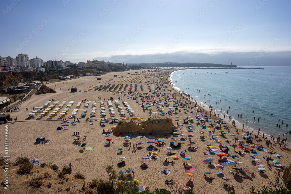 Obraz premium View of Praia da Rocha beach in Portimão, Algarve, Portugal. Golden sand, dramatic cliffs and blue Atlantic ocean under a clear summer sky.