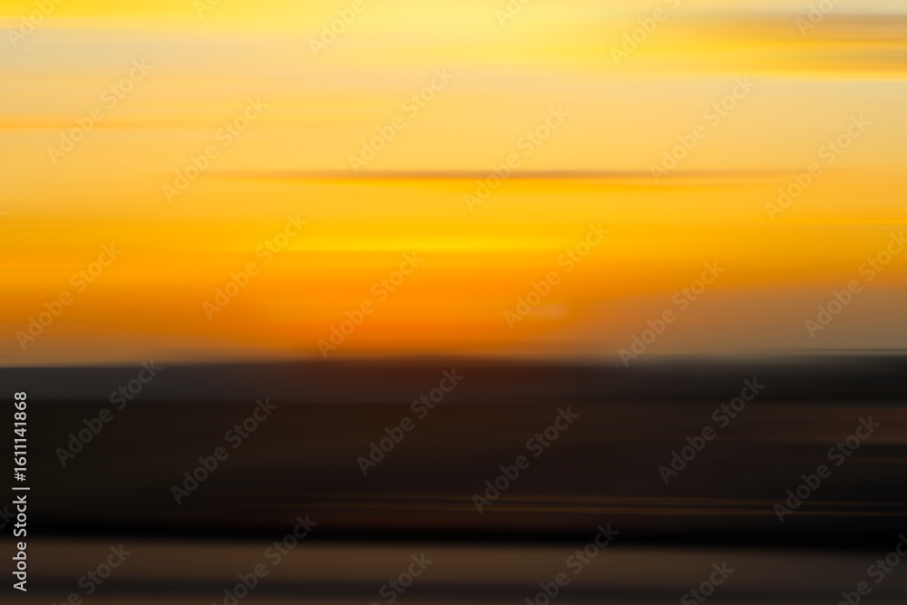 Obraz premium Abstract blurred background of a dawn breaks with warm tones of orange and yellow. Ideal for use in designs, overlays, or nature-themed projects.