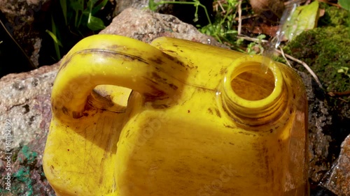 Yellow Plastic Jug Being Filled with Water Outdoors in Indian Village – 4K