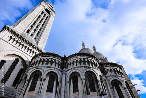 Fotografie Low angle view of Sacre Coeur basilica in Montmartre with blue sky and clouds in