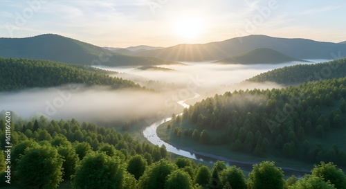 Lush green valley with a winding river shrouded in morning fog and radiant sunlight breaking
