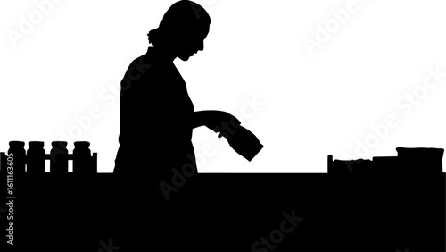 Silhouette of a woman working at a counter with bottles and containers in a dark monochrome setting