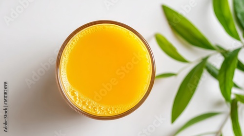 Overhead view of a glass of orange juice set against a white surface
