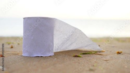 White toilet paper flutters near the sea.