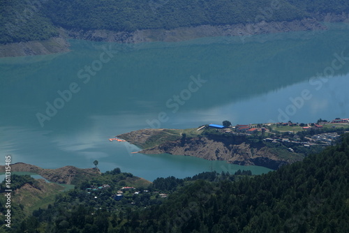 Tehri Lake, nestled in the Garhwal Himalayas of Uttarakhand, is a stunning man-made reservoir created by the Tehri Dam. Surrounded by lush green hills and snow-capped peaks.