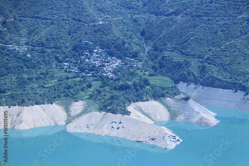 Tehri Lake, nestled in the Garhwal Himalayas of Uttarakhand, is a stunning man-made reservoir created by the Tehri Dam. Surrounded by lush green hills and snow-capped peaks.